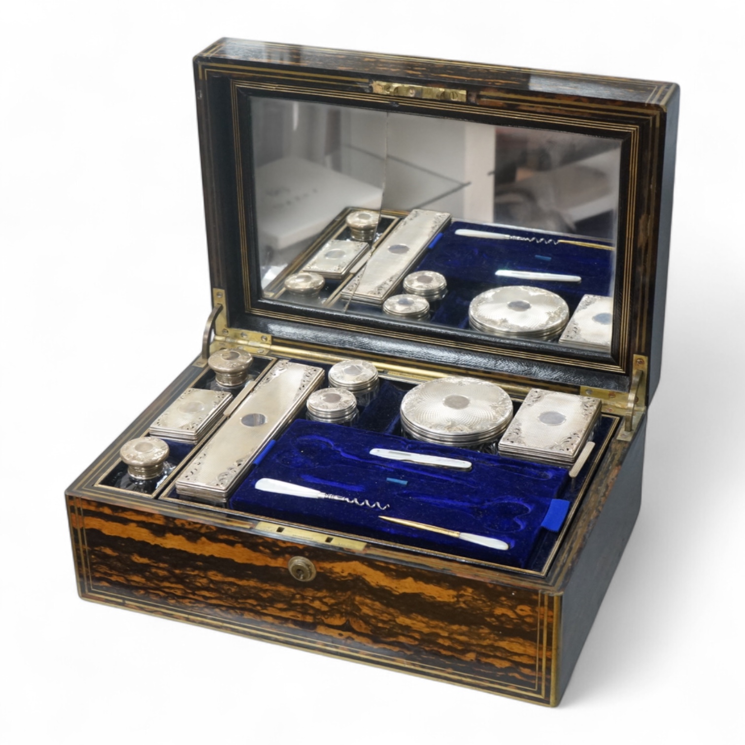 A Victorian brass mounted coromandel wood toilet box by Lund, 57 Cornhill, London, containing eight silver mounted glass toilet jars, six hallmarked for Thomas Johnson I, London, 1865 and three associated? mother of pear